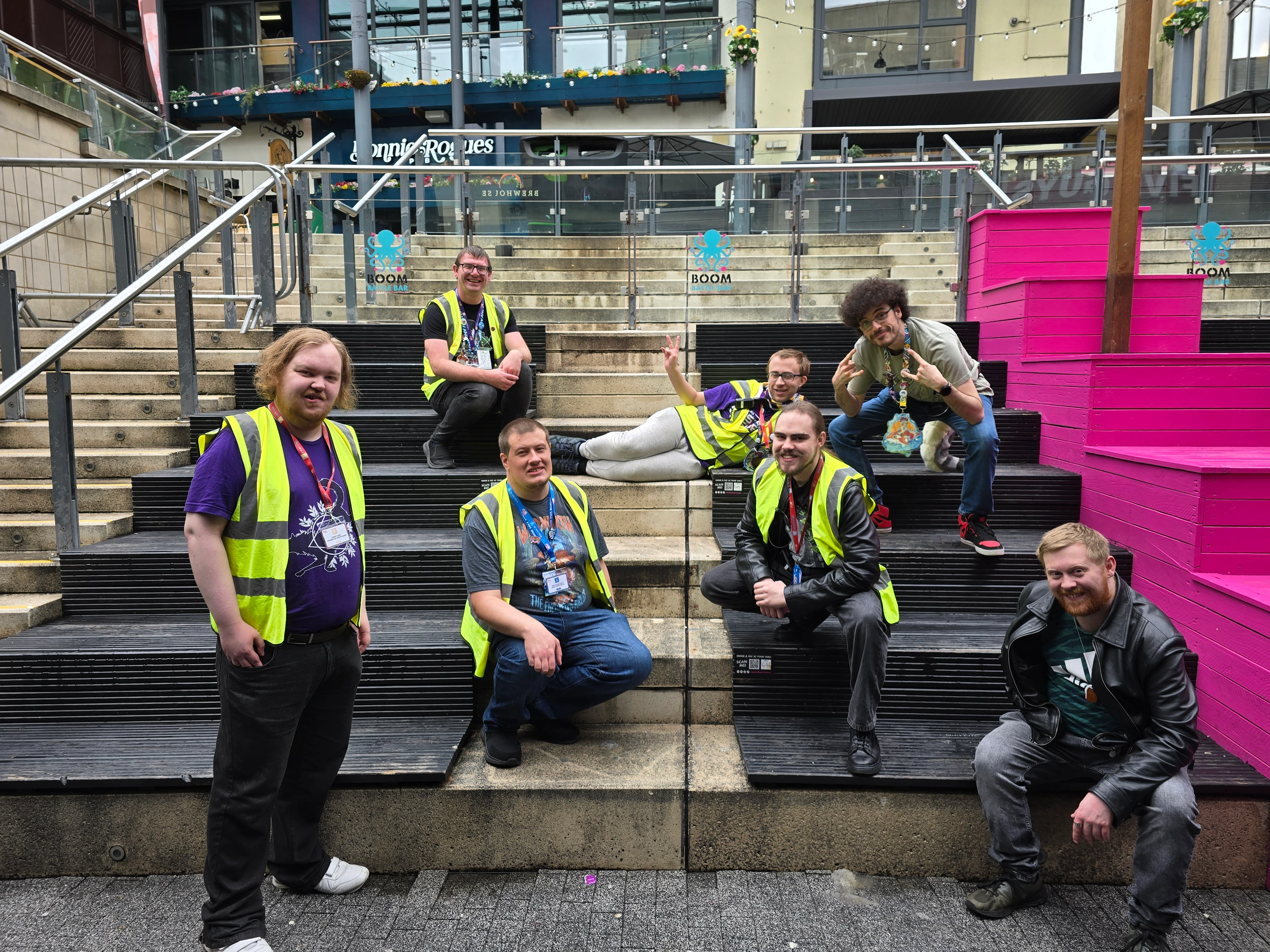 Photo of FurTheMoment staff, some with high visibility, posing for camera - outside on stair seating